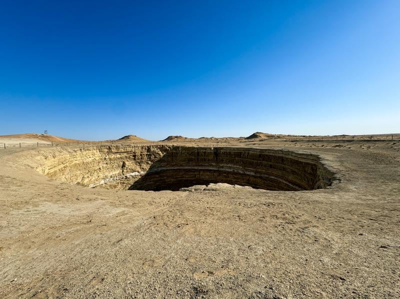 広大な砂漠地帯にあいた巨大なクレーターの写真