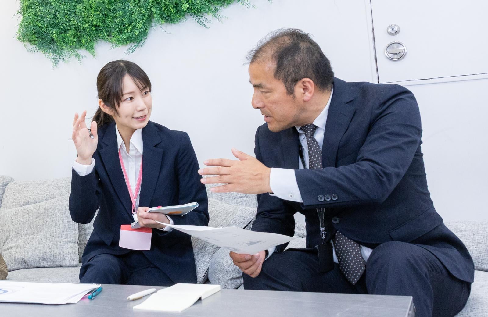 「話を聞かない上司と説明に必死な女性社員の構図」の写真［モデル：高木桂一 SAKI］