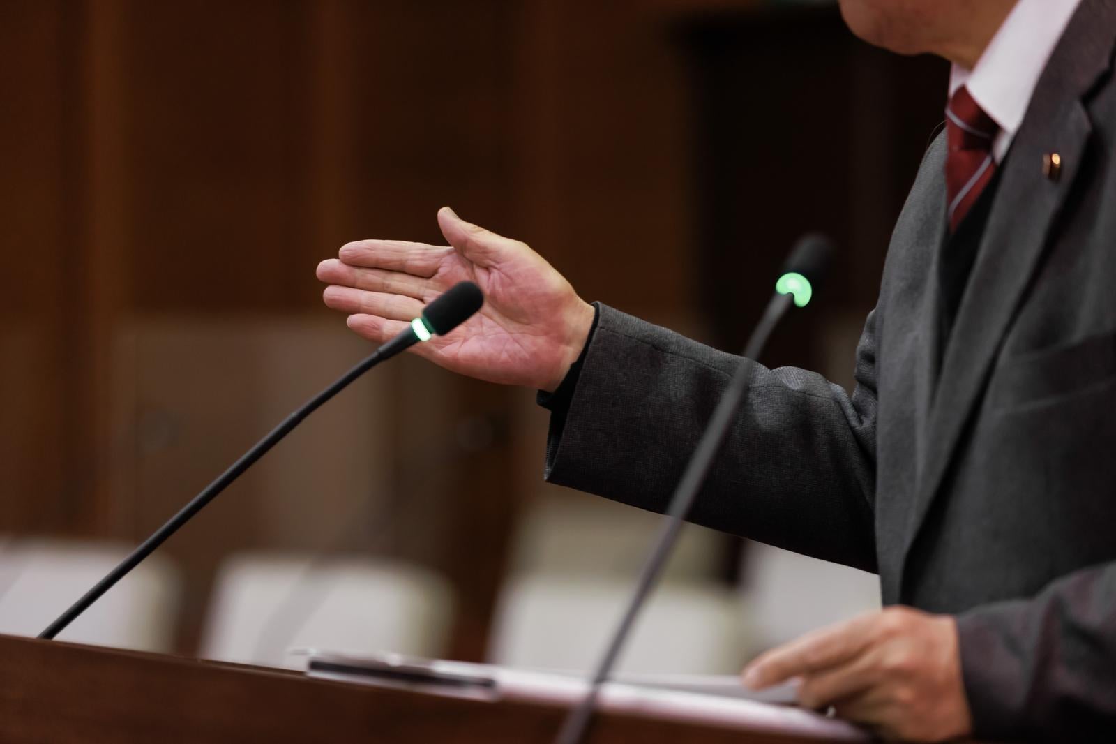 「手のジェスチャーで議論を進行する男性」の写真