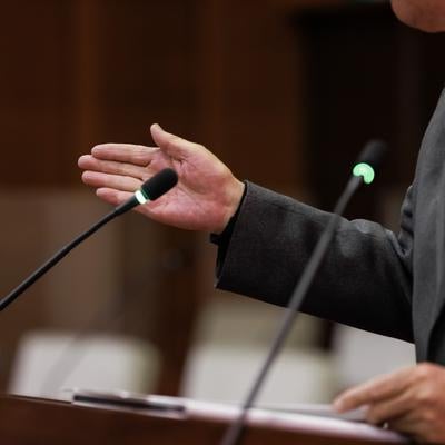 手のジェスチャーで議論を進行する男性の写真