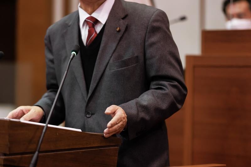 落ち着いたジェスチャーで語る議会の様子の写真