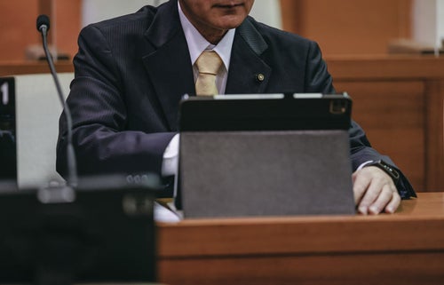 タブレット端末を使いこなす津山市議会の議員の写真