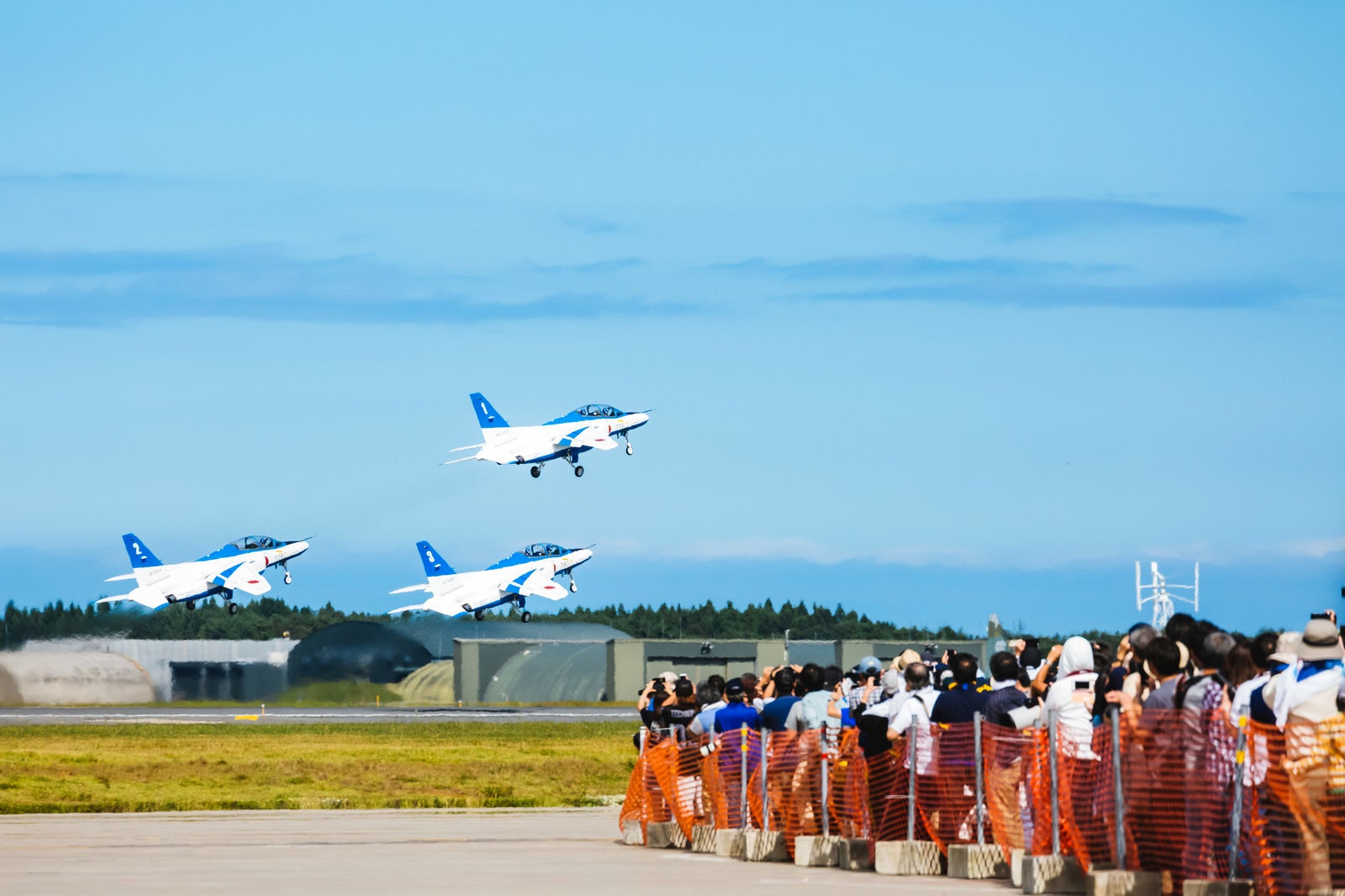 「飛び立つブルーインパルス3機と観客」の写真