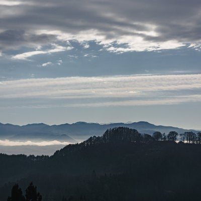 ややかすんで見える葛山城（かつらやまじょう）跡と奥に広がる雲海と連なる山々の写真