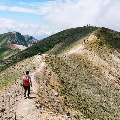 十勝岳から上ホロカメットク山へ歩く登山者の写真