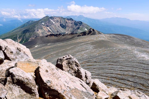 十勝岳山頂から見る美瑛岳と平ヶ岳の大地の写真