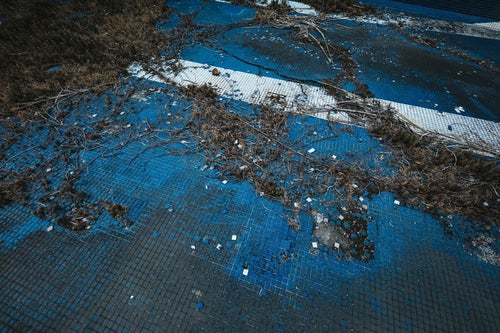 タイルが剥がれたプール跡（廃墟）の写真