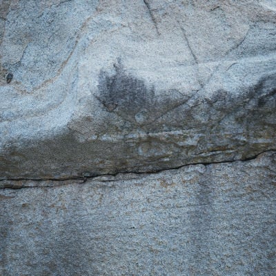 中央に亀裂の入った巨岩の写真