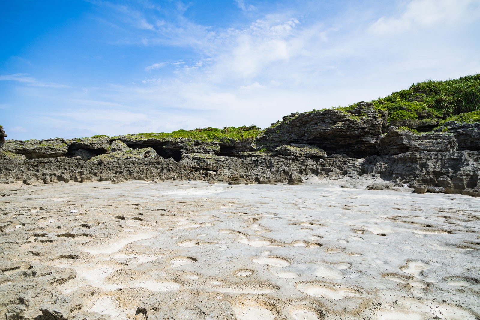 「珊瑚の岩のくぼみと塩田跡ミヤドーバル（犬田布海岸）」の写真