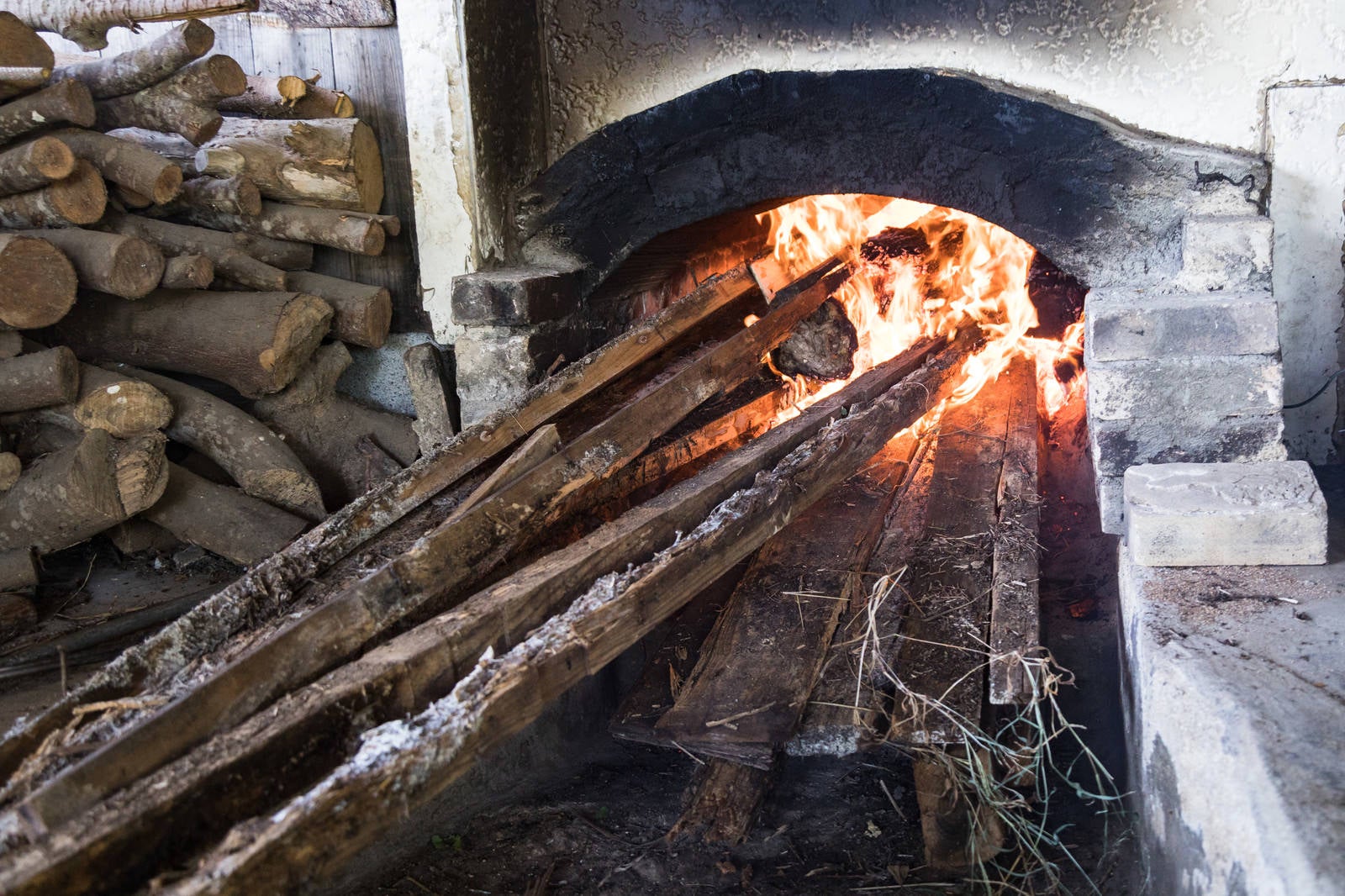 「窯を沸騰させるのに薪を燃やす」の写真