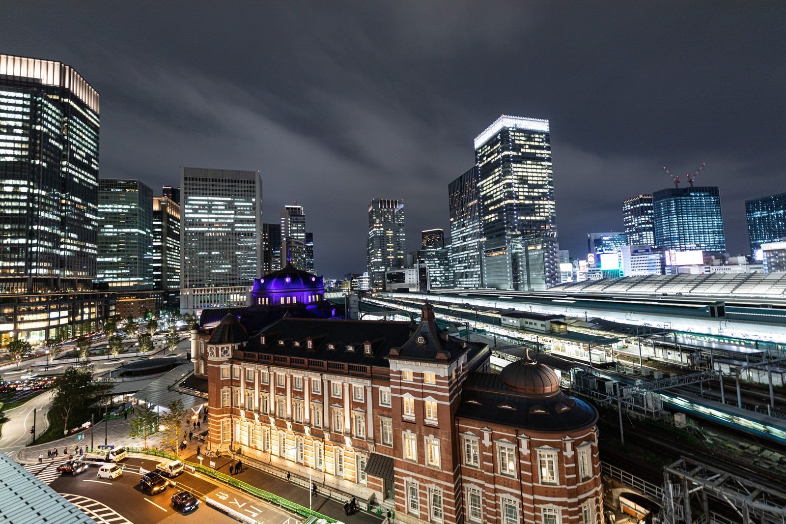 「夜の東京駅越しに見る丸の内ビル群の夜景」の写真