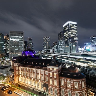 夜の東京駅越しに見る丸の内ビル群の夜景の写真