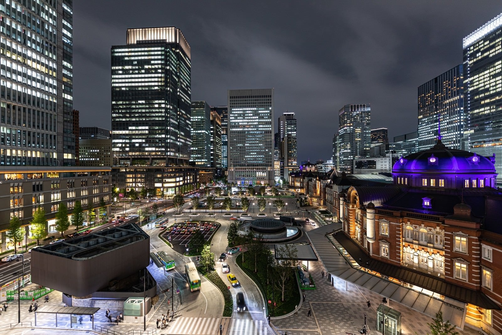「夜の東京駅丸の内駅前広場を取り囲む高層ビル群と駅舎」の写真