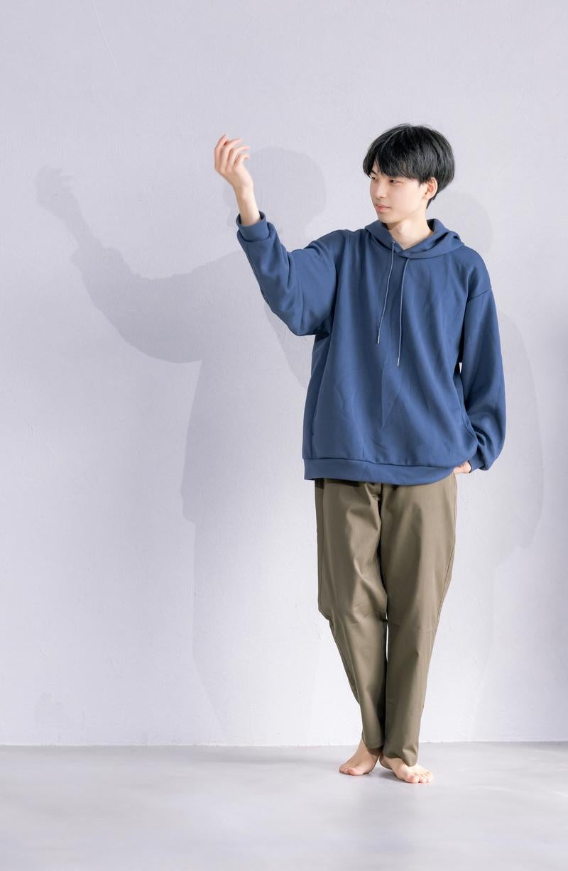 「白い壁を背景にした若い男性のポートレート」の写真［モデル：たくみ］