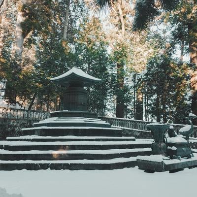 積雪期の奥宮参拝道、暗色の宝塔と石段と境内の写真
