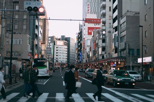 赤信号と歩道を渡る通行人の写真
