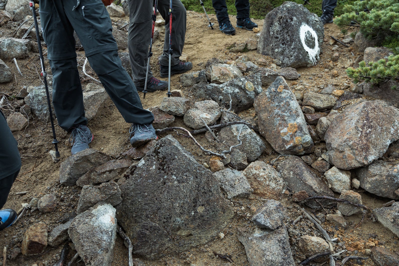 「岩場で休憩する登山家の皆さん（足元）」の写真