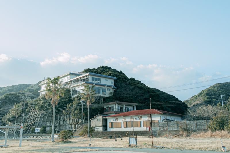 答志島温泉と山上の宿泊施設が見守る風景の写真