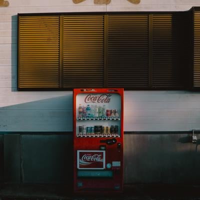 片隅に佇むレトロな赤い自販機の写真