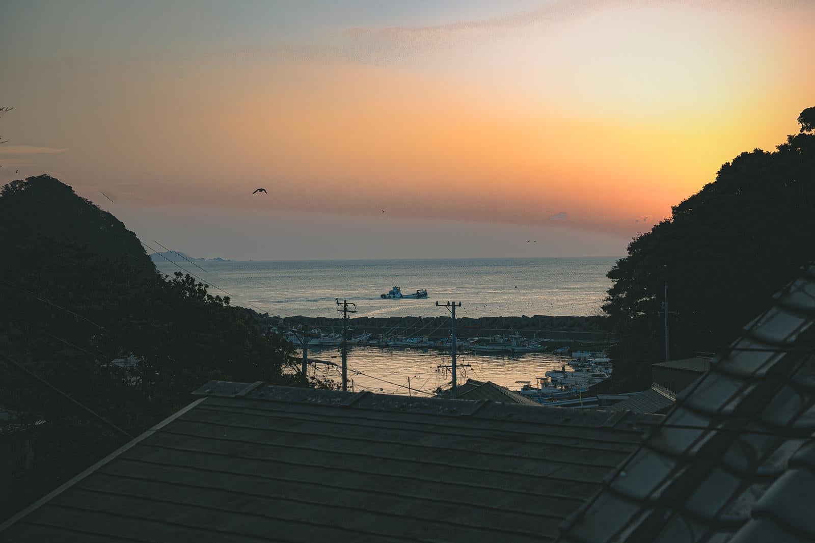 「朝焼けに染まる三重県答志島の漁港」の写真