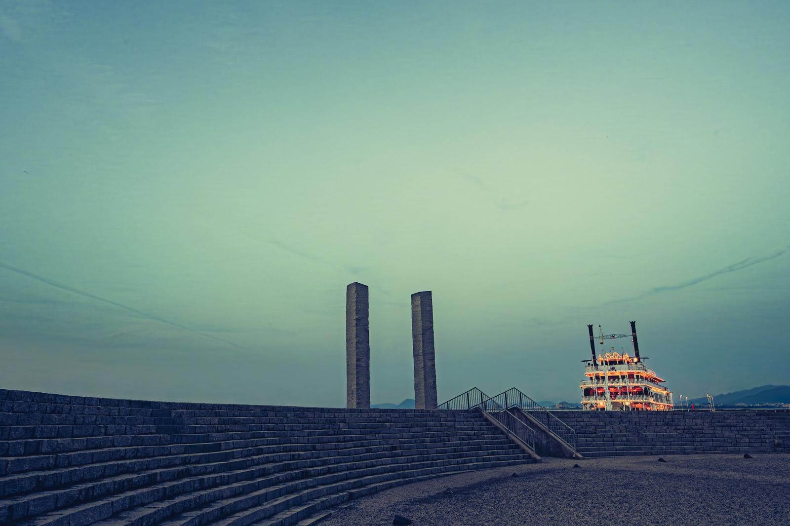 薄曇りの空の下、琵琶湖の円形階段広場とクルーズ船