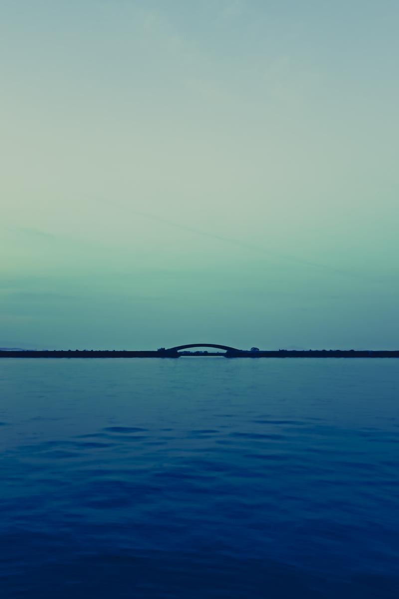 琵琶湖に浮かぶアーチ型の橋の写真
