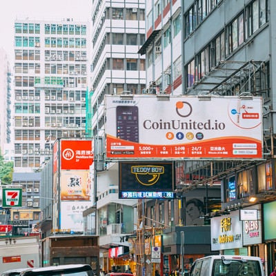 仮想通貨の看板が目立つ香港（尖沙咀）の町並みの写真