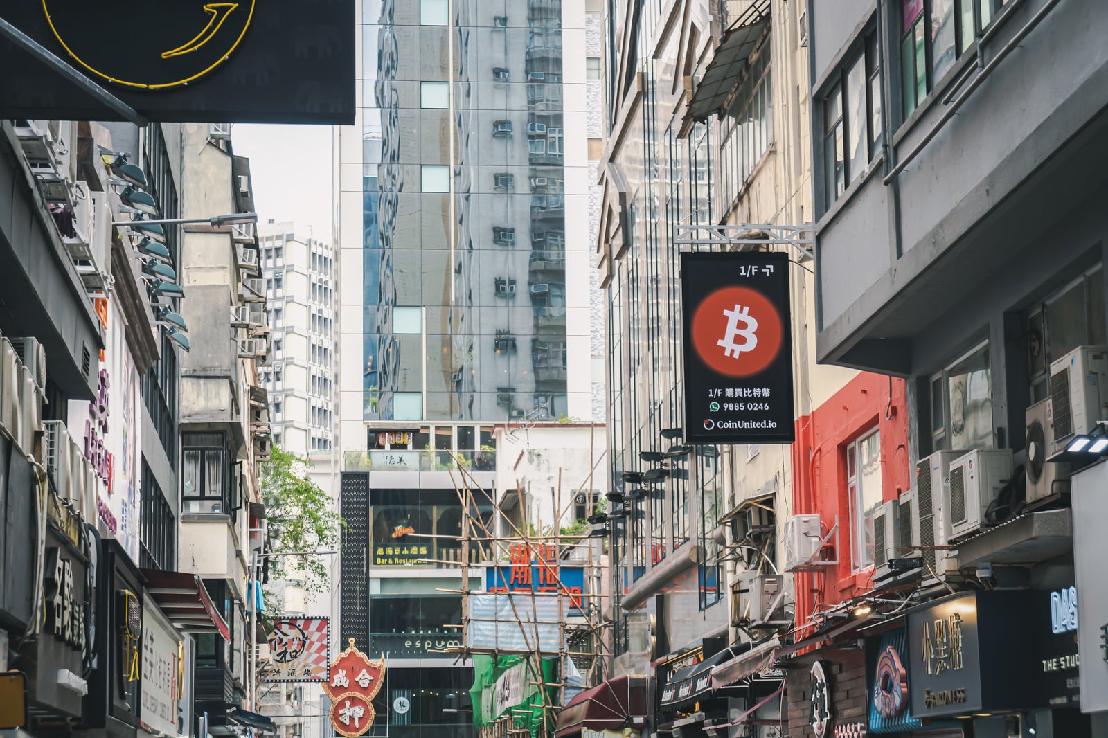 「仮想通貨や令和など色々な店の看板が目立つ香港」の写真