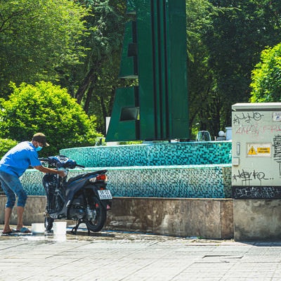 噴水を利用してバイクを洗う東南アジアのライフハックの写真