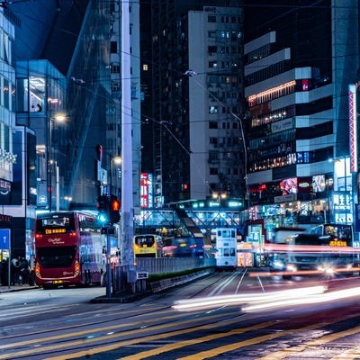 【香港-銅鑼湾】信号待ちしている歩行者の前を走るバスや車の写真