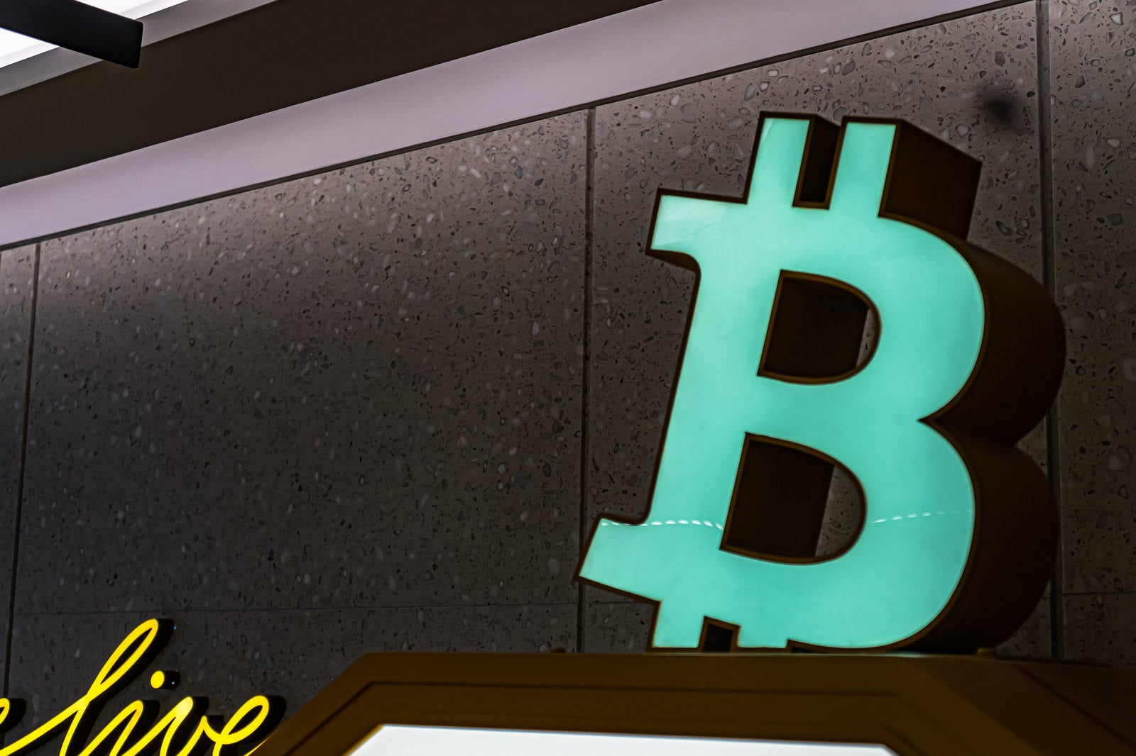 「ビットコインのロゴが掲げられている仮想通貨自動販売機」の写真