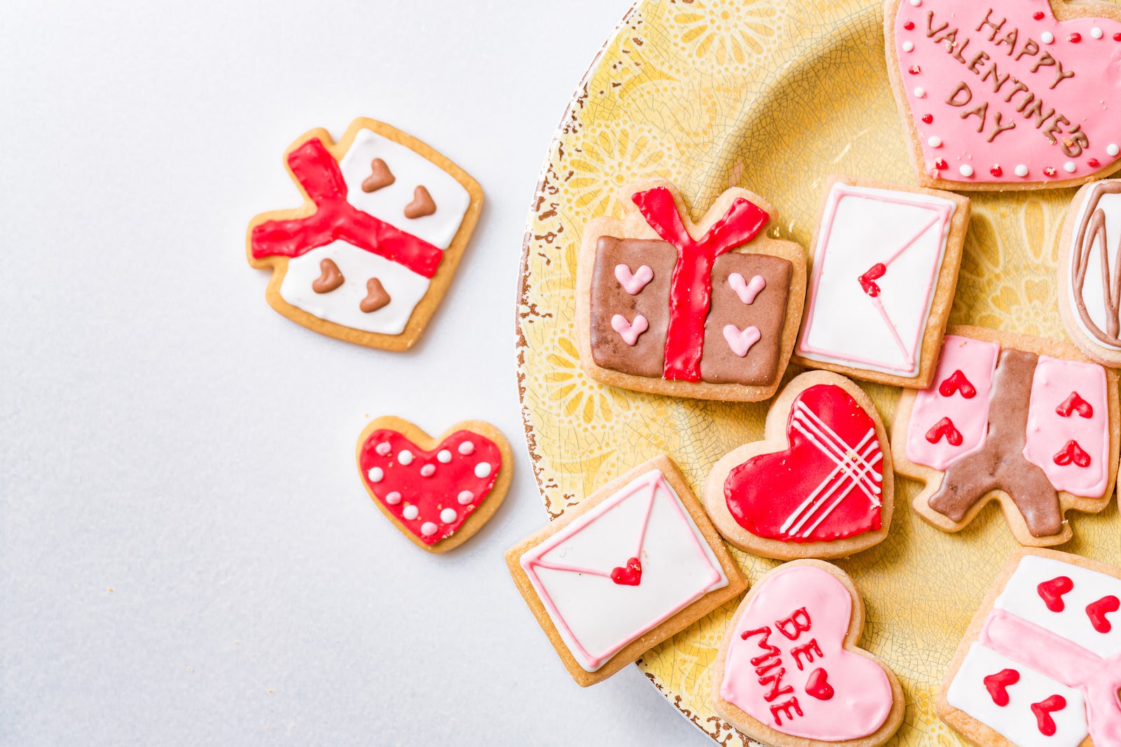 「皿からあふれるバレンタイン用のアイシングクッキー」の写真
