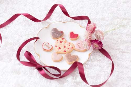 花を添えて並べたバレンタインクッキーの写真
