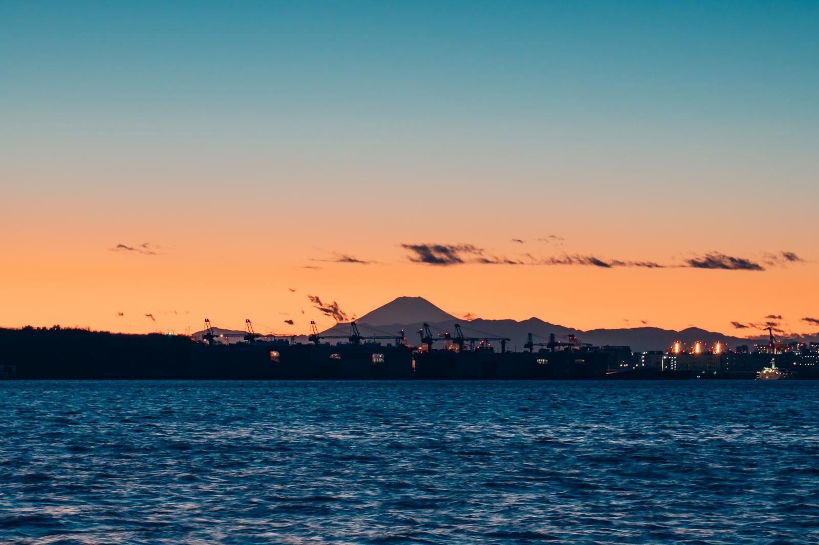 「若洲海浜公園から撮影した夕焼け空の東京湾と富士山のシルエット」の写真
