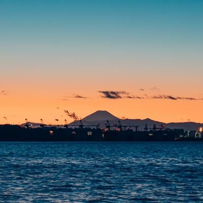 若洲海浜公園から撮影した夕焼け空の東京湾と富士山のシルエットの写真