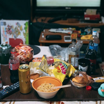 食べ残しやゴミが散乱する汚部屋のテーブルの写真