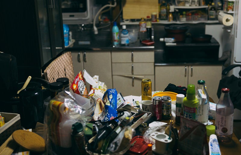 空き缶やゴミが散乱した汚部屋のキッチンの写真