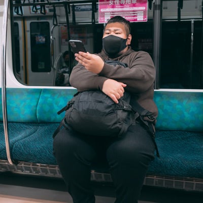 電車の席に座る160キロの男性の写真