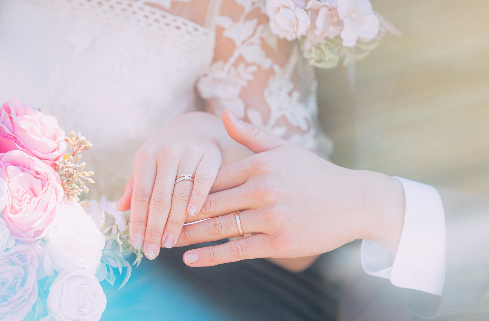 「結婚指輪をはめる新郎新婦の手」の写真［モデル：河村友歌］