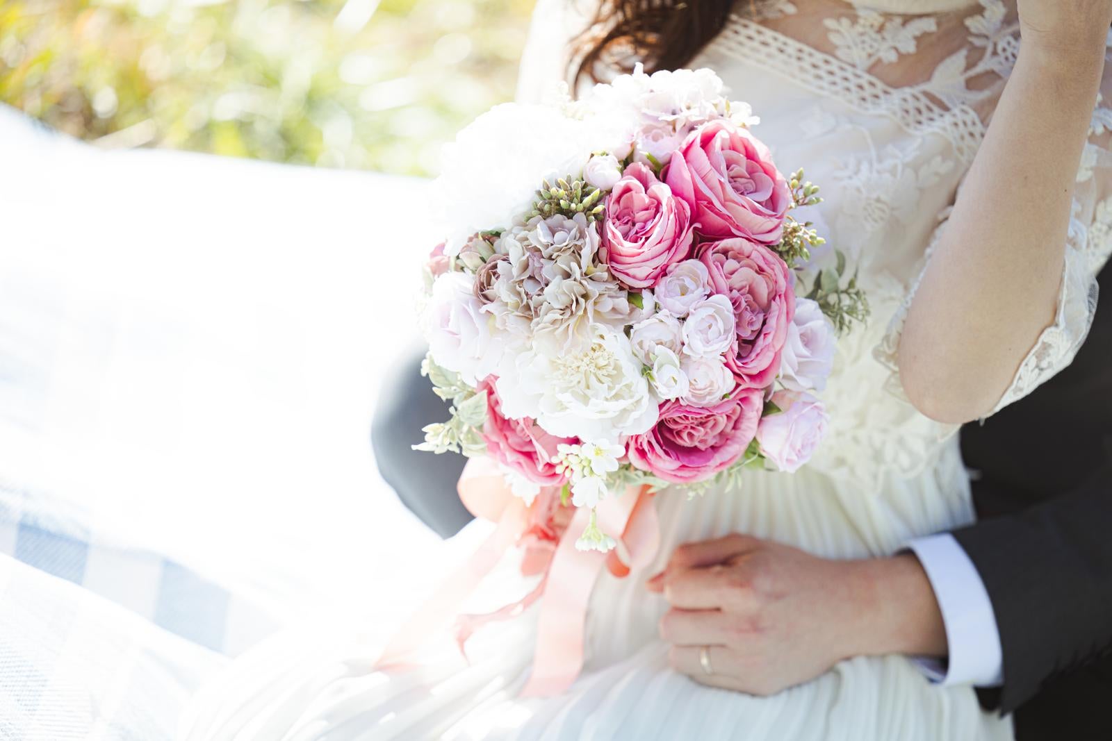 「ブライダルの花束と新婚夫妻の手元」の写真［モデル：河村友歌］