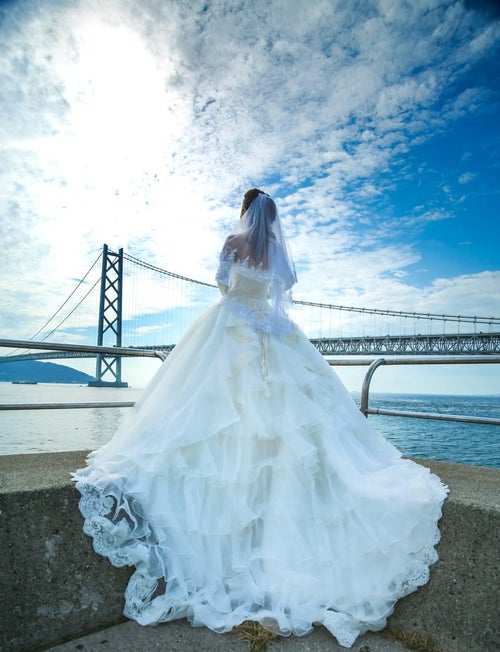 明石海峡大橋とウェディングドレス姿の女性の写真