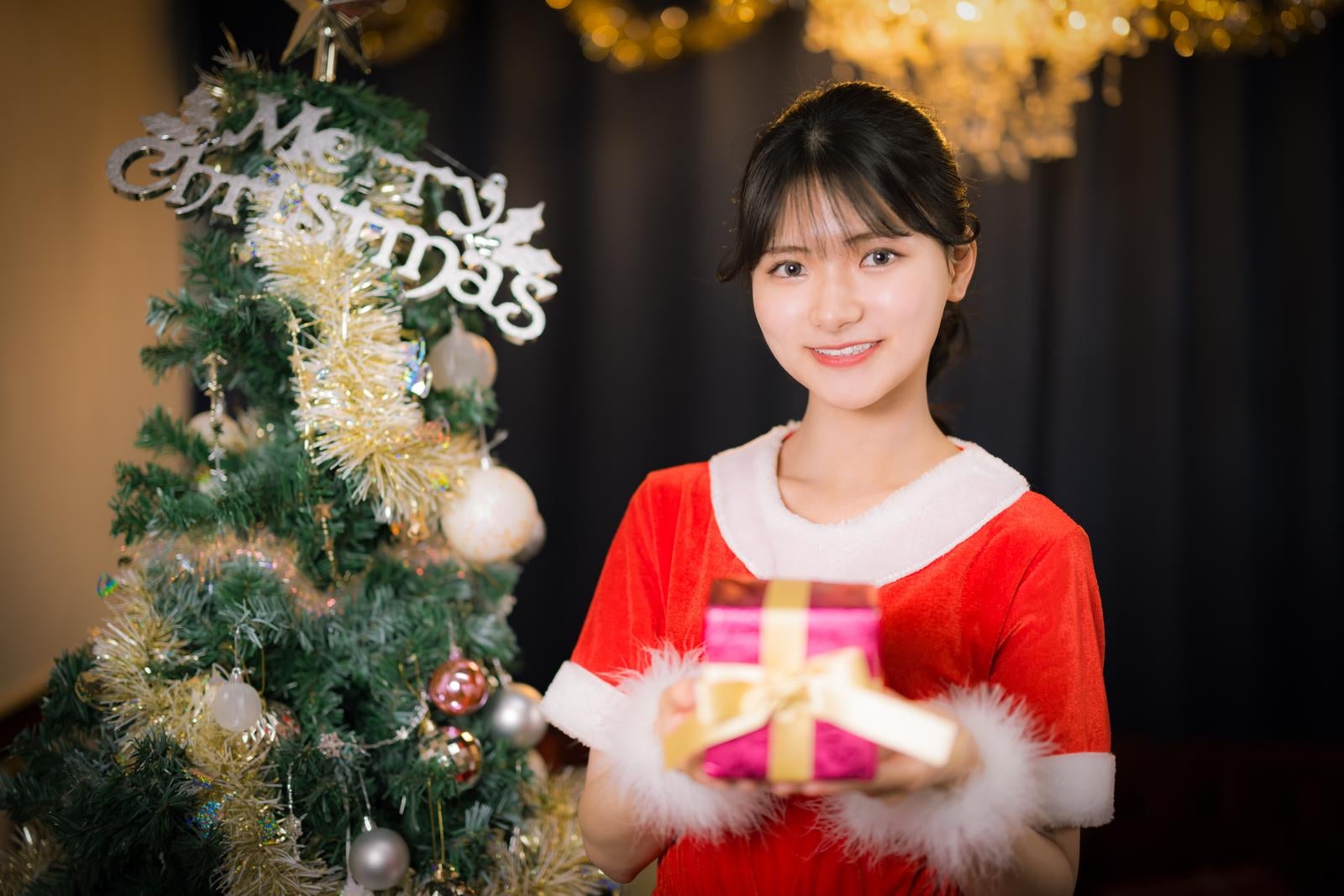 「クリスマスの日にプレゼントを配る女性店員」の写真［モデル：モデルリリース］