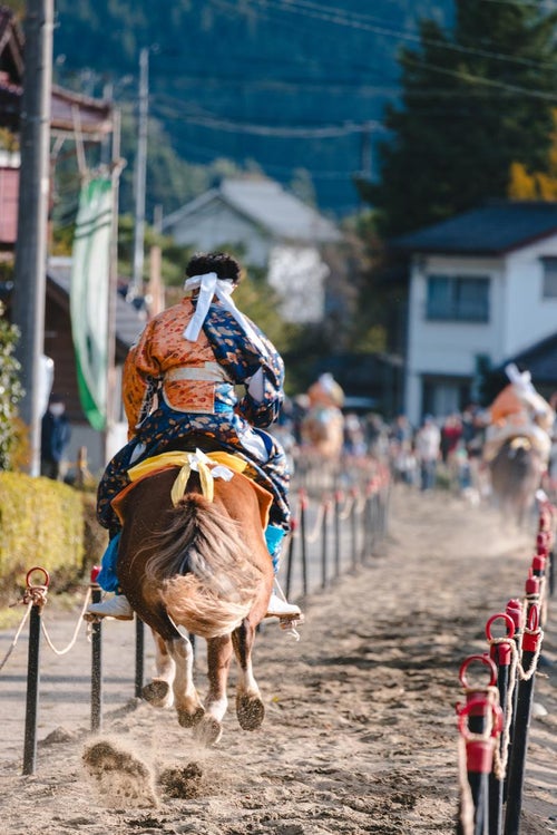 古殿八幡神社例大祭の流鏑馬コースを疾走するの写真