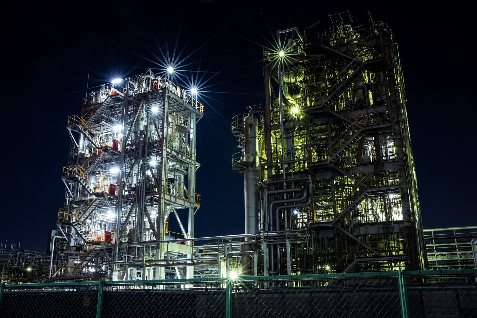 川崎千鳥町の工場夜景、強いライトから光芒が放射状に広がる