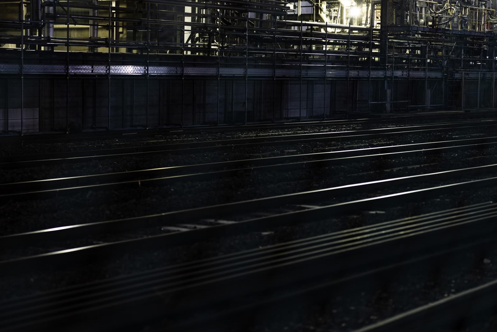 「線路に反射する工場の明かり」の写真