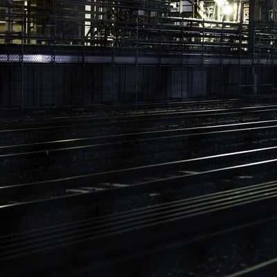 線路に反射する工場の明かりの写真