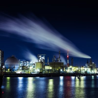 夜空に流れる排煙と工場夜景の写真