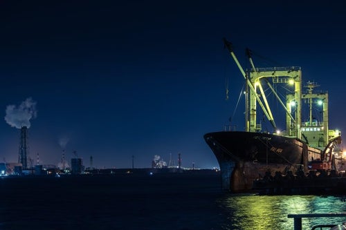 工場夜景と大型タンカーの写真