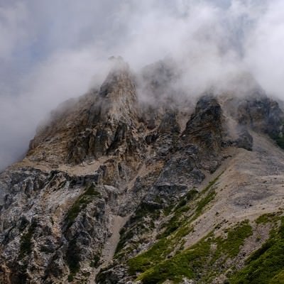 沸き立つガスに包まれた岩山（白馬岳）の写真