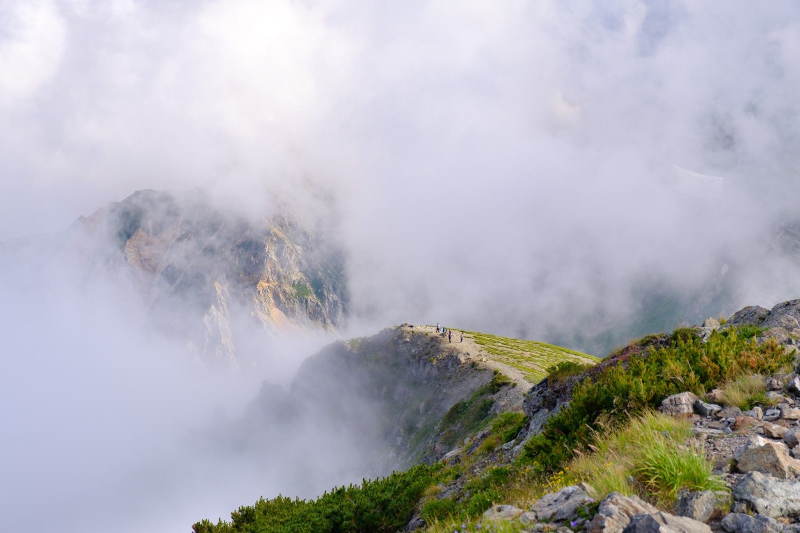 「ガスに隠れた杓子岳と切れ間からあられる登山道（杓子岳）」の写真